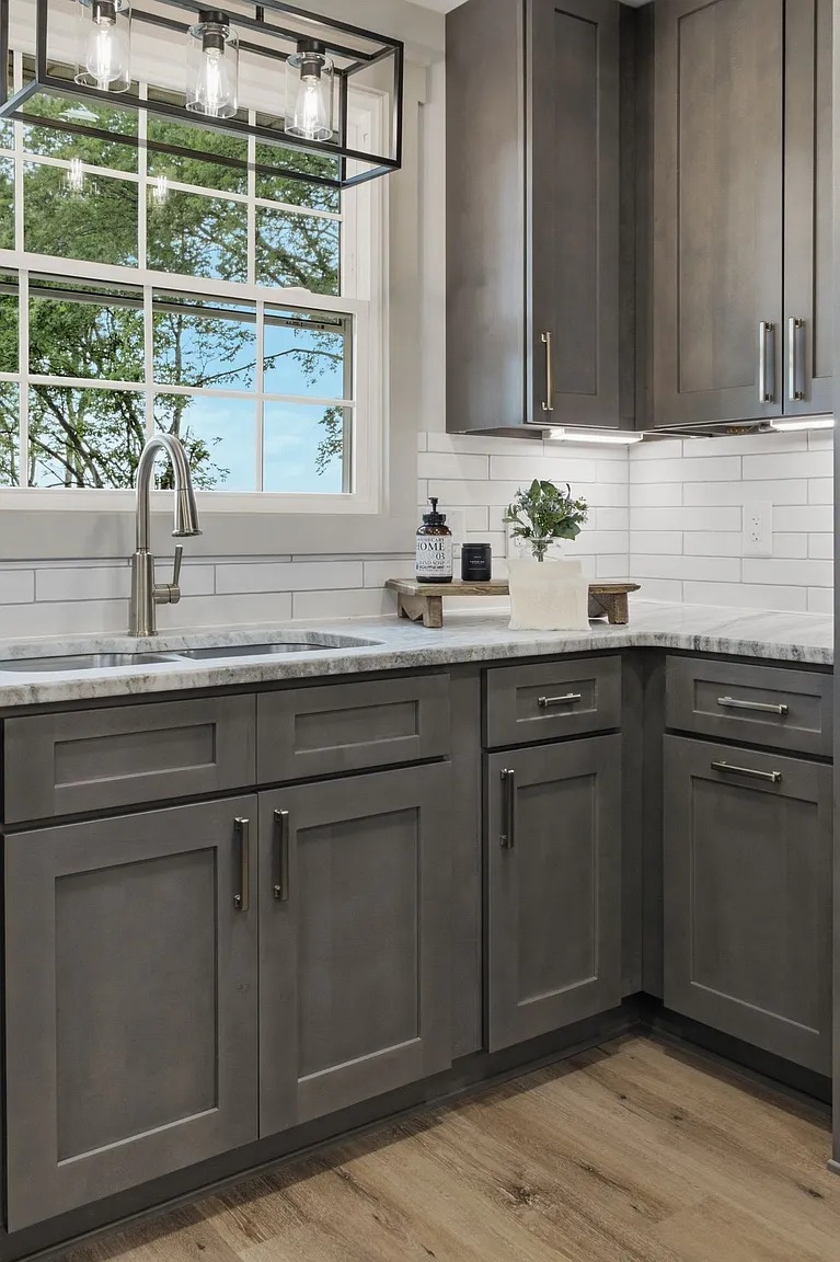 Grey shaker laundry-room cabinetry around a corner sink